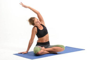 Beyaz arka plan üzerinde yoga yaparken güzel genç kadın