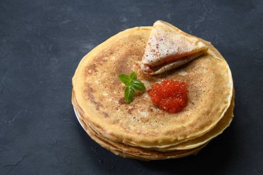 Koyu rustik arka plan üzerinde kırmızı havyar ile krep yığını, üst görünümü