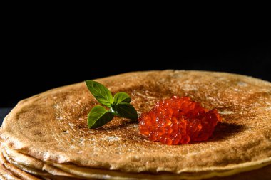 Siyah arka plan üzerinde kırmızı havyar ile krep yığını, yakın