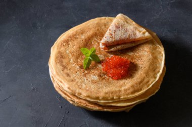 Koyu rustik arka plan üzerinde kırmızı havyar ile krep yığını, üst görünümü