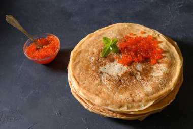 Koyu rustik arka plan üzerinde kırmızı havyar ile krep yığını, üst görünümü