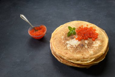 Koyu rustik arka plan üzerinde kırmızı havyar ile krep yığını, üst görünümü