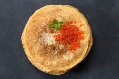 Koyu rustik arka plan üzerinde kırmızı havyar ile krep yığını, üst görünümü