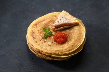 Koyu rustik arka plan üzerinde kırmızı havyar ile krep yığını, üst görünümü