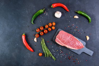 Koyu arka planda çiğ mermer et ve baharatlar.