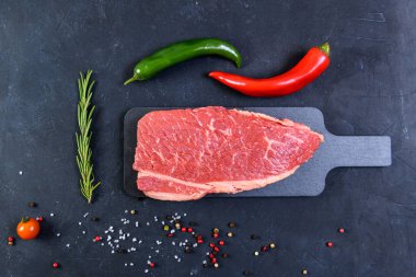 Koyu arka planda çiğ mermer et ve baharatlar.