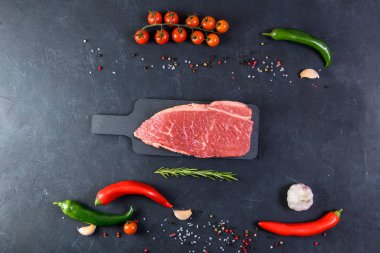 Koyu arka planda çiğ mermer et ve baharatlar.