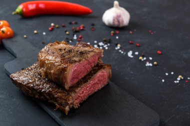 Koyu arkaplanda az pişmiş ızgara biftek.