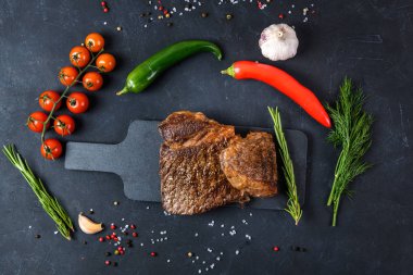 Arka planda az pişmiş ızgara biftek ve pirzola.