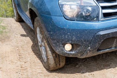 Kirli araba tekerleği kırsal bir yolda yakınlaşıyor. Off road konsepti. 4x4