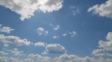 Dinamik zaman dilimi, parlak mavi gökyüzünde kayan tüylü beyaz bulutları gösteriyor, zamanın ve hareketin geçişini yakalıyor..