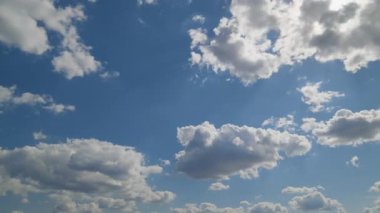 Parlak gündüz gökyüzü, dağınık kabarık beyaz bulutlar mavi arka planda huzur içinde sürükleniyor. Hava, doğa ve rahatlama temaları için ideal..