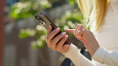 Dışarıdaki akıllı telefonları yeşil bokeh ile dinleyen, cep telefonlarını, sosyal medyayı, mesajlaşmayı ve modern iletişimi gösteren kadınların yakın çekimleri.