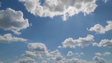 Pofuduk beyaz bulutların dinamik görüntüsü parlak mavi bir gökyüzünde sürükleniyor, doğal hareketi göstermek için zaman dilimi tarzında yakalanıyor..