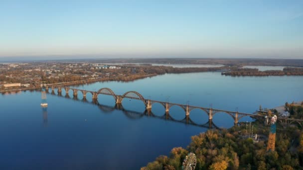 ドニプロ市内ドニエプル川の上の鉄道橋のドローンから空中平面図です 秋の風景や街並みの背景 ドネプロペトロフスク ドニエプル ドニエプロペトロフスク — ストック動画