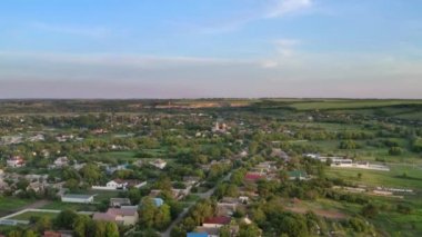 Yaz günü Ukrayna 'daki küçük bir köyün üzerinden uçacağız. Yüksekten manzara manzarası var. Yeşil doğanın 4k hava görüntüsü.