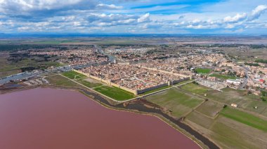 Fransa 'daki pembe gölün kıyısındaki ortaçağ kasaba kalesi. Hava görünümü.