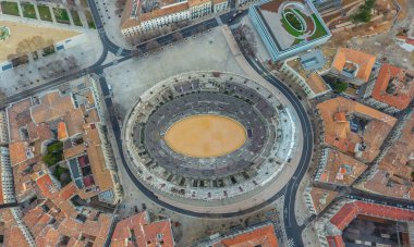 Şehir binalarıyla çevrili antik arenanın üst manzarası. Nimes, Fransa.