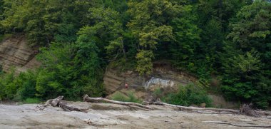 Kurumuş nehrin büyük kıyısına karşı duran adam.