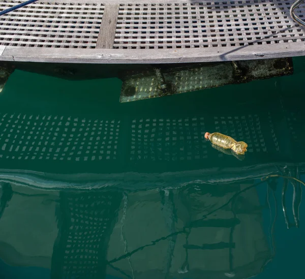 A plastic bottle floats on the surface of the water near the boat berth. — Stock Image Plastic Bottle Floats Surface Water Boat Berth Stock Picture