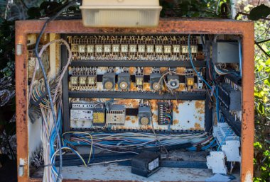 Dışarıdaki çöplükte sigorta ve kablolar olan paslı elektrik kutusu..