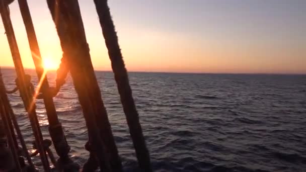 古い帆船のシュラウドとリギングを通して日没 シースケープスローモーションビデオ — ストック動画