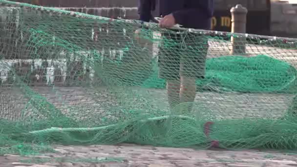 Man repairing green fishing net. — Stock Footage Man Repairing Green Fishing Net Stock Video