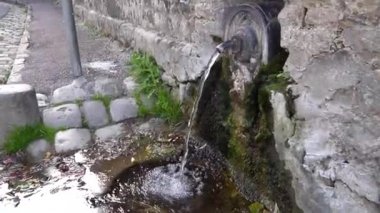 Atlar için eski bir çeşme. Kaldırımdaki su birikintisi.