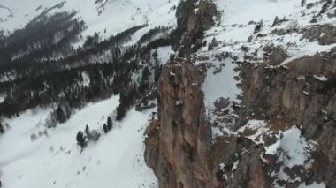 Uçurumun, ormanın ve kayaların kardaki görüntüsü..