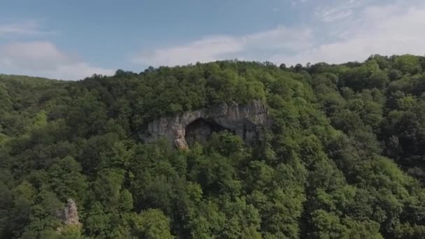 Vista Aérea Gruta Roca Cima Una Colina Boscosa Retrocede — Vídeo de stock