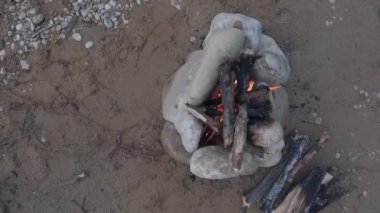 Nehrin kumlu kıyısında kamp ateşi. Üst görünüm.