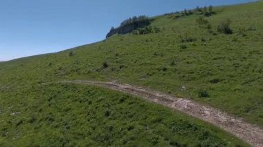 Yeşil bir tepenin yamacındaki kayalar. Hava görünümü.