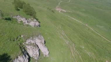 Yeşil bir tepenin yamacındaki kayalar. Hava görünümü.