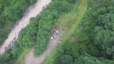 Dağ nehri yakınlarındaki ormandaki ATV kampının hava görüntüsü..