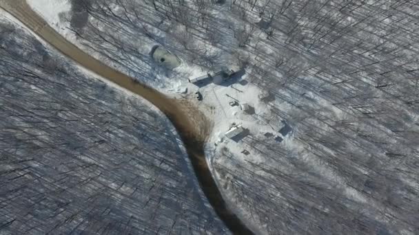 Vue de dessus d'une route sinueuse dans une forêt de montagne enneigée.