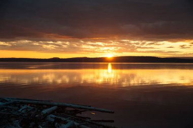 Gün batımı. Bulutlar suya yansıyor. Kureiskaya rezervuarı. Yaz. Krasnoyarsk bölgesinin kuzeyinde..