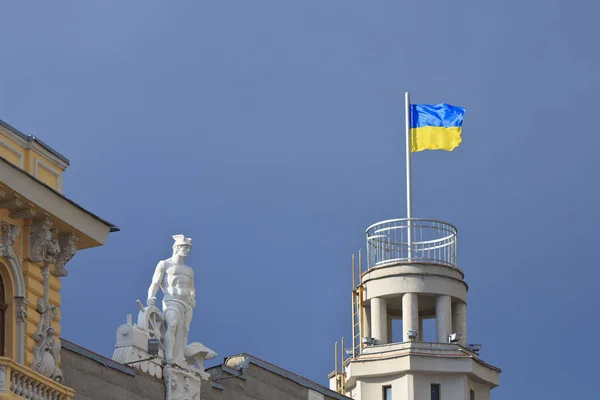 Die Statue Des Quecksilbers Und Die Nationalflagge Vor Dem Hintergrund — Stockfoto