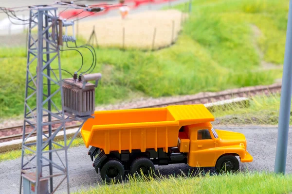 Orange truck in H0 scale on model train road