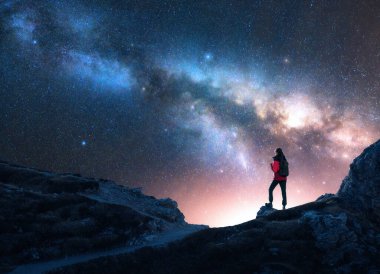 Parlayan Samanyolu ve yıldızlı gecede dağın zirvesinde bir kadın. Dolomitler, İtalya. Galaksi. Bir kızın siluetiyle uzay manzarası, kayalar, parlak yıldızlı gökyüzü. Samanyolu ve yürüyüşçü. Gece manzarası