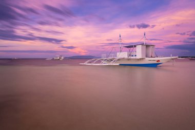 Geleneksel Filipinli Bangka tekneleri günbatımında bir plajda, Panglao, Filipinler