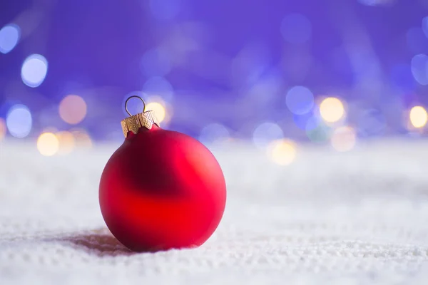 Boule Noël Rouge Sur Tissu Tricoté Blanc Sur Fond Violet — Photo