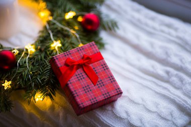 Portre hediye kutusu şenlikli dekorasyon kırmızı Noel topları ve sıcak garland ışıkları yakın. Yeni yıl hediyesi.