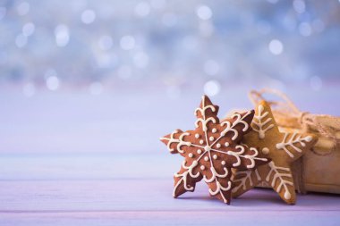 Çikolata kar tanesi ve ışık bokeh arka plan üzerinde yıldız şeklinde sırlı şenlikli Noel kurabiyesi. Tatil fırını. Yeni yıl tatlı hediye.