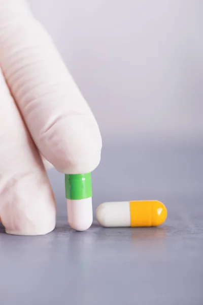 Closeup Hand Medical Latex Glove Holding Two Different Colorful Capsules — Stock Photo, Image