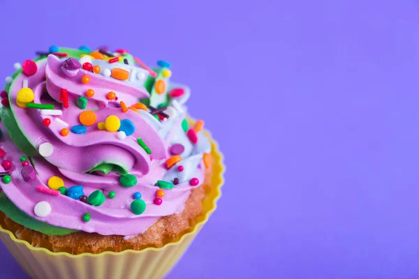 クローズ アップ カップケーキ クリーミー色とりどりのトップ紫色の背景にカラフルな振りかけるの 誕生日パーティーやクリスマス ケーキ — ストック写真