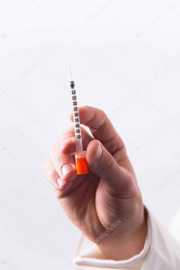 Male doctor hand holding one insulin syringe on white background. Concept of insulin therapy of diabetes.