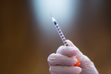 Doktor el lastik eldiven beyaz zemin üzerine açık insülin şırınga tutarak. İnsülin tedavisi Diyabet kavramı.