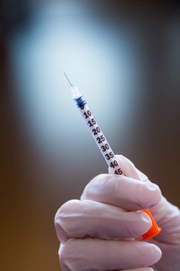 Doktor el lastik eldiven beyaz zemin üzerine açık insülin şırınga tutarak. İnsülin tedavisi Diyabet kavramı.