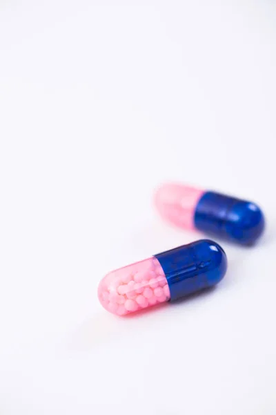 Closeup Dva Tmavě Modré Růžové Transparentní Kapsle Mikro Granule Uvnitř — Stock fotografie