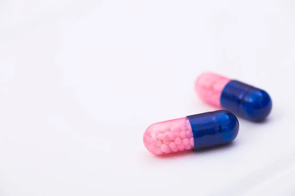 Closeup Two Dark Blue Pink Transparent Capsules Micro Granules White — Stock Photo, Image